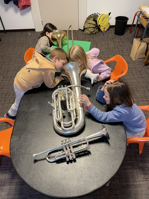 enfants découvrant des instruments de la famille des cuivres (trompette, trombone, baryton)